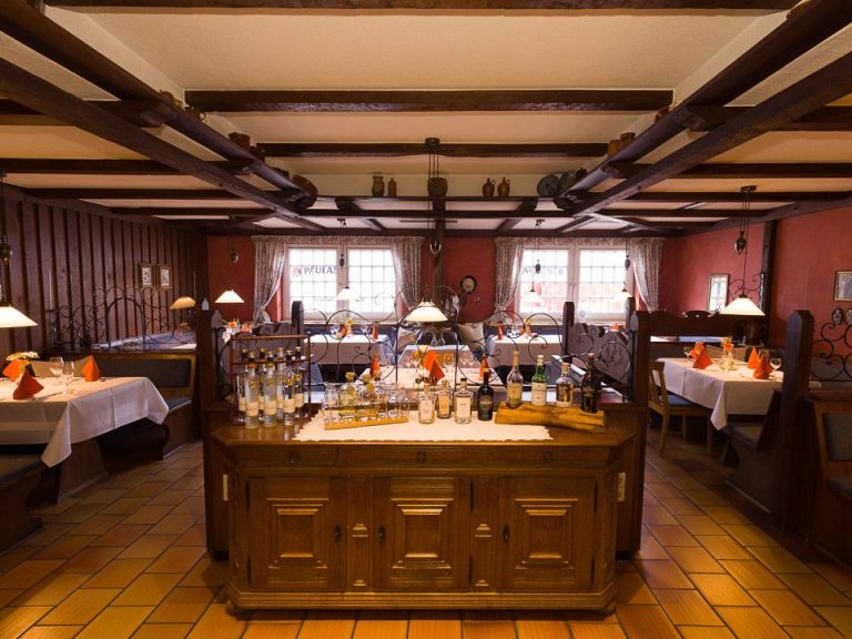 Gemütliches Restaurant mit Holzinterieur, Tischen und stilvoller Dekoration.